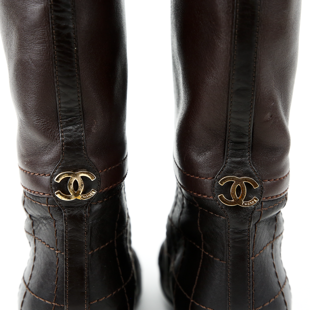 CC charm accent view of Chanel Brown Leather Quilted Knee High Boots